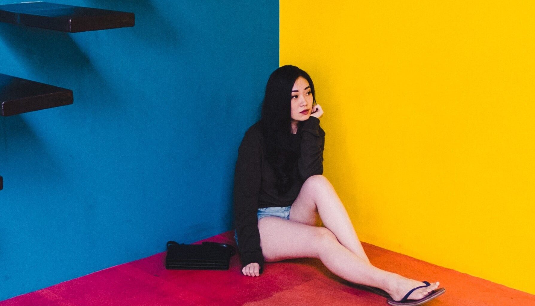 bright colour asian woman seated near stairs
